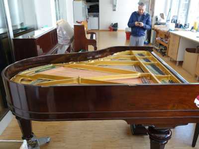 Il pianoforte riverniciato e lucidato durante la fase conclusiva del restauro 